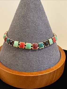 Gold tone bracelet featuring multicolor enamel inlay tiles